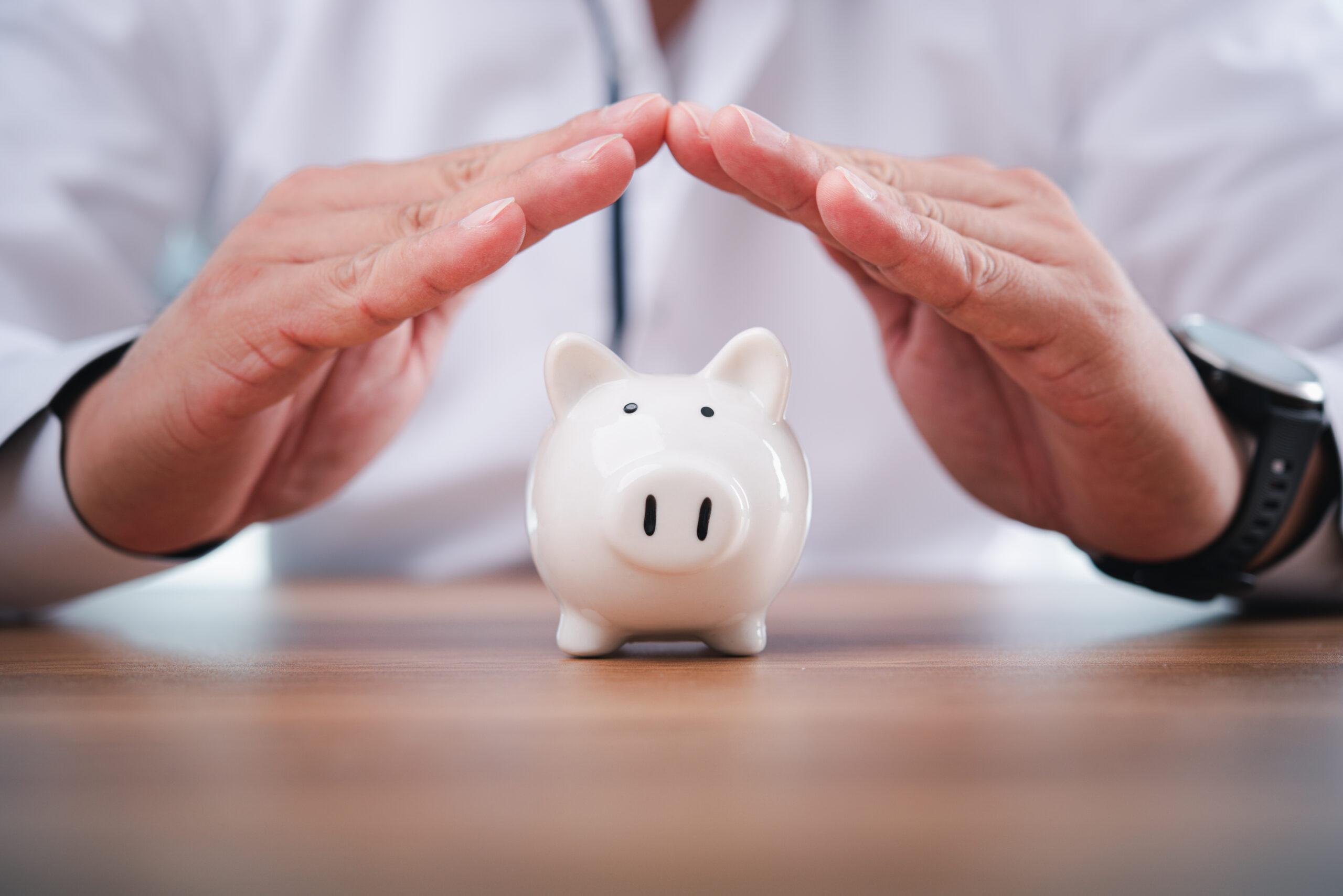 Businessman take a position to protect the piggy bank in hand